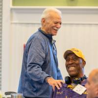 An alumni putting his hand on another alumni's shoulder.